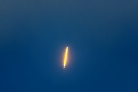 Long distance view of rocket in heavy cloud cover.