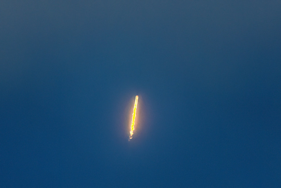 Long distance view of rocket in heavy cloud cover.