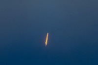 Long distance view of rocket in heavy cloud cover.